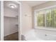 Bright bathroom featuring a large soaking tub, walk-in closet, and natural light from the window at 464 Meadowbrook Dr, Mcdonough, GA 30253