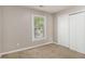 Neutral bedroom with a window view and white closet doors at 464 Meadowbrook Dr, Mcdonough, GA 30253