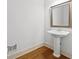 Elegant half bath showcasing a pedestal sink, modern mirror, and clean design on hardwood floors at 51 Sagemont Ct, Acworth, GA 30101