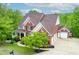 Beautiful brick home with a well-manicured lawn and a three-car garage surrounded by lush trees at 51 Sagemont Ct, Acworth, GA 30101