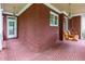 Spacious brick porch with hanging swing and a view of the front yard and entrance at 51 Sagemont Ct, Acworth, GA 30101