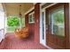 Inviting front porch with a wooden swing, brick facade, and glass-paneled front door at 51 Sagemont Ct, Acworth, GA 30101