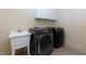 Laundry room with white utility sink, modern washer and dryer, and overhead cabinets at 51 Sagemont Ct, Acworth, GA 30101