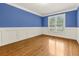 Bright living room featuring hardwood floors, crown molding, and a large window letting in natural light at 51 Sagemont Ct, Acworth, GA 30101