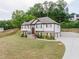 Charming two-story home featuring brick accents, red door, landscaped yard, and two-car garage at 204 Arapahoe Ct, Villa Rica, GA 30180