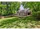 View of the backyard showing the house with a wooden deck and steps leading to the fenced yard at 1362 Briarcliff Ne Rd, Atlanta, GA 30306