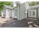 Exterior view showcasing an outdoor wooden deck with doors leading into the grey brick home at 1362 Briarcliff Ne Rd, Atlanta, GA 30306