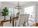 Bright dining area with white trim, a modern chandelier, and view to a charming sunroom at 1362 Briarcliff Ne Rd, Atlanta, GA 30306