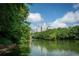 Scenic lake view with lush green trees and a distant skyline under a bright blue sky at 1362 Briarcliff Ne Rd, Atlanta, GA 30306