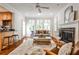 Beautiful living room featuring a fireplace, large windows with plantation shutters, and an open view to the kitchen at 1362 Briarcliff Ne Rd, Atlanta, GA 30306