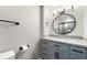 Modern bathroom with granite countertops, storage, and a round mirror at 2663 Lowell Dr, Morrow, GA 30260