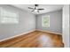 Well-lit bedroom featuring wood floors, a ceiling fan, and two windows at 2663 Lowell Dr, Morrow, GA 30260