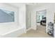 Bright bathroom featuring a soaking tub and a glass enclosed shower, with a glimpse into the adjacent bedroom at 3060 Elmwood Ct, College Park, GA 30349