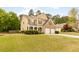 Traditional two-story home featuring a well-kept lawn, brick accents, and an attached two-car garage at 3060 Elmwood Ct, College Park, GA 30349