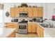 Well-lit kitchen featuring light wood cabinets, stainless steel appliances, and a tiled backsplash at 3060 Elmwood Ct, College Park, GA 30349