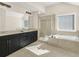 Elegant bathroom featuring a double vanity, tiled shower, and a relaxing soaking tub under a bright window at 4343 Ainsley Mill Ln, Duluth, GA 30097
