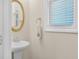 Bathroom with pedestal sink, decorative mirror, and a window with blinds at 4343 Ainsley Mill Ln, Duluth, GA 30097