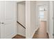 Bright hallway leading to a bedroom and stairs, with a door on the left at 4343 Ainsley Mill Ln, Duluth, GA 30097