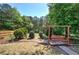 A backyard featuring a wooden swing set and mature trees, creating a relaxing outdoor space at 5221 Huntcrest Sw Pl, Mableton, GA 30126