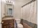Bathroom with granite countertops, wood cabinets, and a shower with patterned curtain at 5221 Huntcrest Sw Pl, Mableton, GA 30126