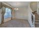 Bright dining room featuring neutral carpeting, wainscoting, chandelier and view to the staircase at 5221 Huntcrest Sw Pl, Mableton, GA 30126