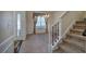 Inviting entryway featuring a decorative front door, staircase, and elegant chandelier lighting the adjacent dining area at 5221 Huntcrest Sw Pl, Mableton, GA 30126