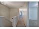 Hallway with neutral carpet and paint, leading to multiple rooms with an ornate chandelier at 5221 Huntcrest Sw Pl, Mableton, GA 30126
