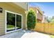 Green backyard featuring well-maintained grass, a concrete patio, a wooden fence, and a sliding glass door at 7705 Bellmist Dr, Fairburn, GA 30213