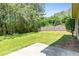 Green backyard featuring well-maintained grass, trees, and a concrete patio at 7705 Bellmist Dr, Fairburn, GA 30213