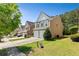 Well-manicured front yard and exterior view of a two-story home with a two car garage and neutral paint at 7705 Bellmist Dr, Fairburn, GA 30213