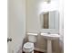 Cozy half bathroom features a pedestal sink, white fixtures, and is complemented by warm lighting at 7705 Bellmist Dr, Fairburn, GA 30213