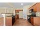 Well-lit kitchen featuring wooden cabinetry, granite countertops, and hardwood flooring at 7705 Bellmist Dr, Fairburn, GA 30213