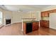 Open-concept kitchen features wooden cabinets and bar seating, open to a living area with a fireplace at 7705 Bellmist Dr, Fairburn, GA 30213