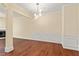 Bright open-concept living area with hardwood floors, decorative columns, and stylish light fixture at 7705 Bellmist Dr, Fairburn, GA 30213