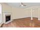 Comfortable living room featuring a cozy fireplace, hardwood floors, and stylish ceiling fan at 7705 Bellmist Dr, Fairburn, GA 30213