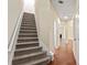 Carpeted staircase leading to an open area with hardwood floors and a view of the fireplace at 7705 Bellmist Dr, Fairburn, GA 30213