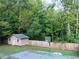 Spacious backyard featuring a shed, a basketball hoop, and a wooden privacy fence at 821 Tramore Ct, Powder Springs, GA 30127