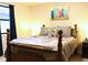 A cozy bedroom with a bed, side table, and colorful art on the wall at 821 Tramore Ct, Powder Springs, GA 30127
