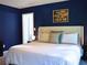 Comfortable bedroom with blue walls, a soft bed, and bedside lamps for a relaxing ambiance at 821 Tramore Ct, Powder Springs, GA 30127