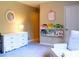 A cozy bedroom with a white dresser, bookshelves, and comfortable armchair at 821 Tramore Ct, Powder Springs, GA 30127