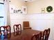 Dining room with white wainscoting, a dark wood table, and seating for four, perfect for formal dinners at 821 Tramore Ct, Powder Springs, GA 30127