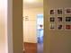 Hallway with framed pictures on the wall, and an entryway to the kitchen in the background, filled with light at 821 Tramore Ct, Powder Springs, GA 30127