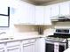Clean kitchen with white cabinets, a stainless steel oven, and a modern range hood at 821 Tramore Ct, Powder Springs, GA 30127