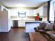 Open-concept kitchen and living area with hardwood floors and an island with white cabinets at 821 Tramore Ct, Powder Springs, GA 30127