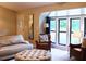 Comfortable living room with a leather arm chair and sofa, large windows, an ottoman, and a view of the home's exterior at 821 Tramore Ct, Powder Springs, GA 30127