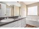 Bathroom featuring dual sinks, bathtub, and lots of light at 1000 Brushystone Dr, Loganville, GA 30052