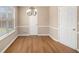 Bright dining room with wood floors, chair rail, and a charming chandelier at 1000 Brushystone Dr, Loganville, GA 30052