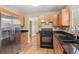 Modern kitchen with black appliances, granite countertops, and wood cabinetry at 1000 Brushystone Dr, Loganville, GA 30052