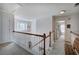 Upstairs hallway with natural light, carpeted floors, and a wooden railing at 192 Adelaide Xing, Acworth, GA 30101