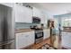Well-lit kitchen with stainless steel appliances, white cabinets, and hardwood floors at 192 Adelaide Xing, Acworth, GA 30101